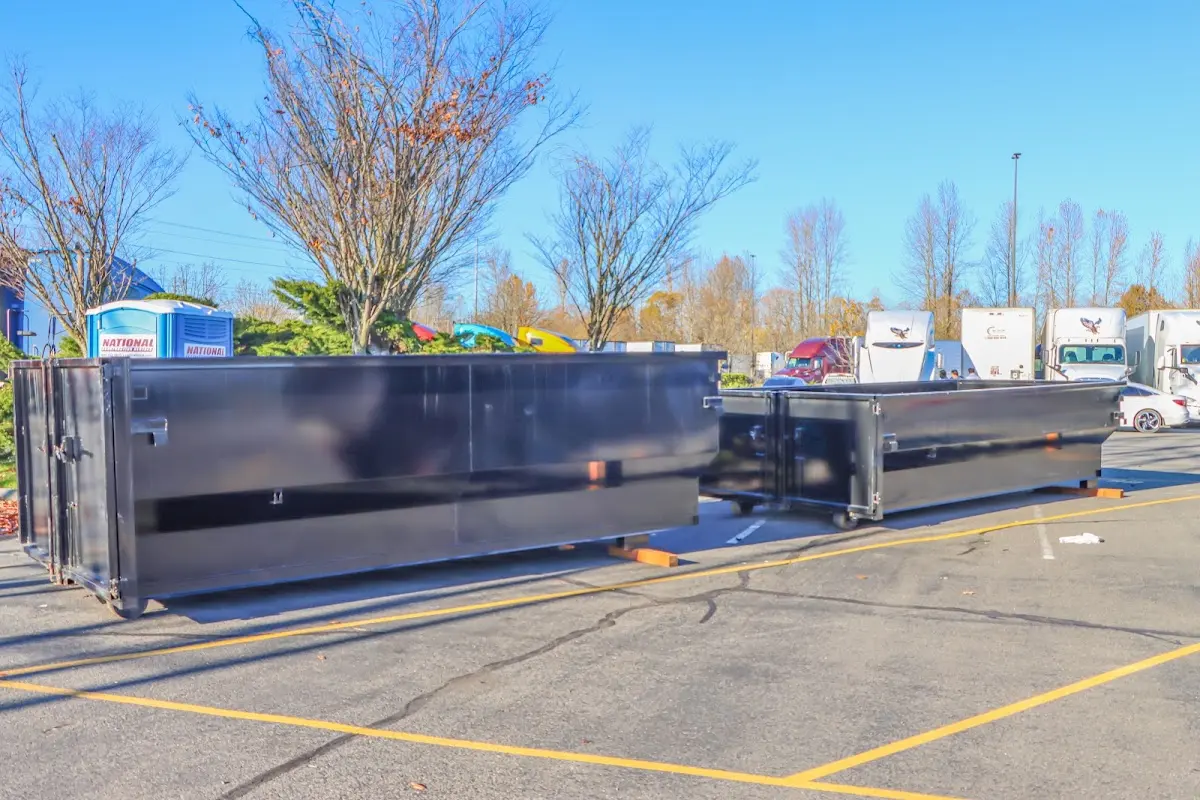 Professional dumpster rental service with roll-off container on residential driveway in Madera